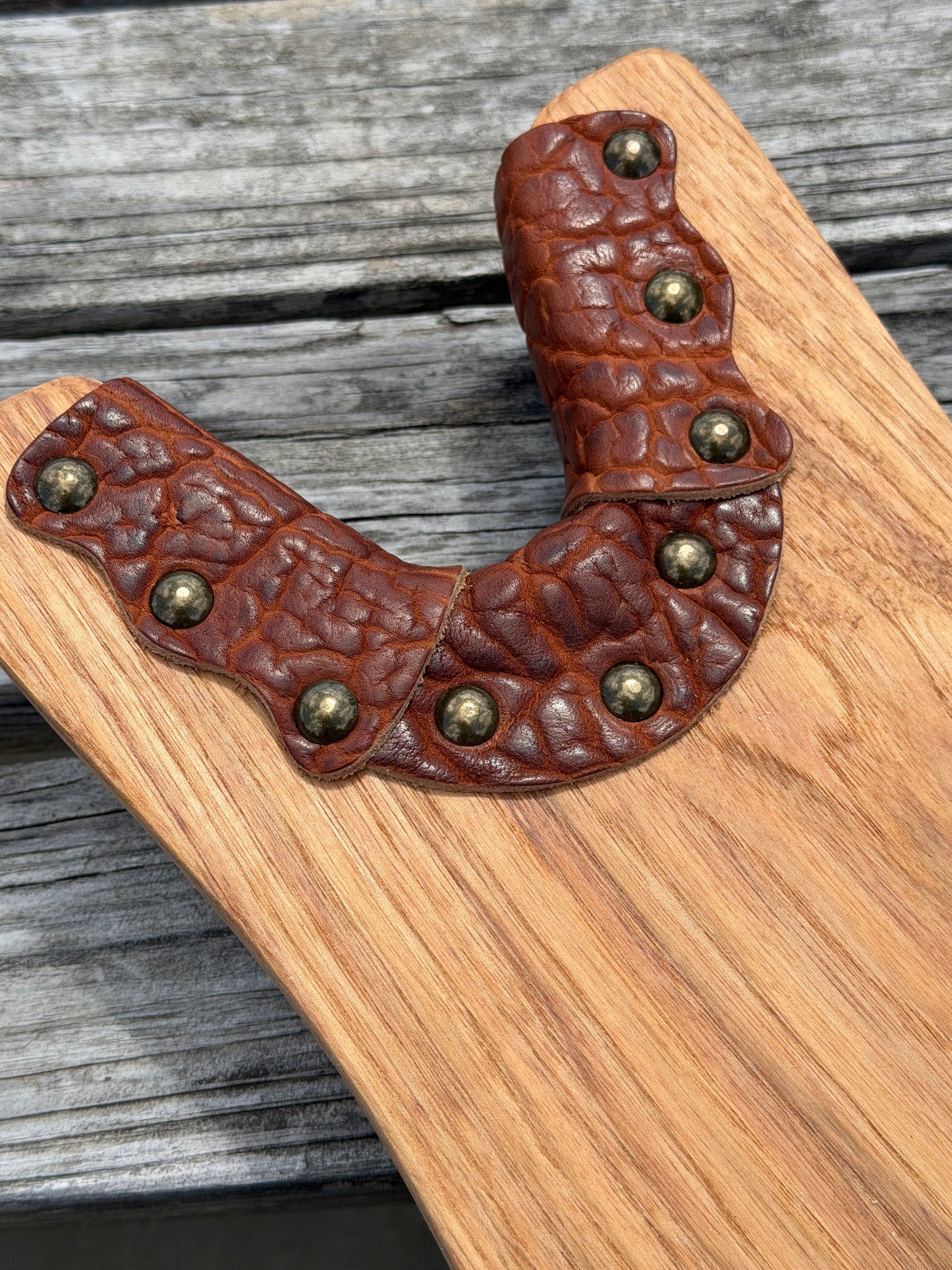 Close up view of bison leather accent from Wyoming with solid brass hardware on a boot jack for removing boots with ease