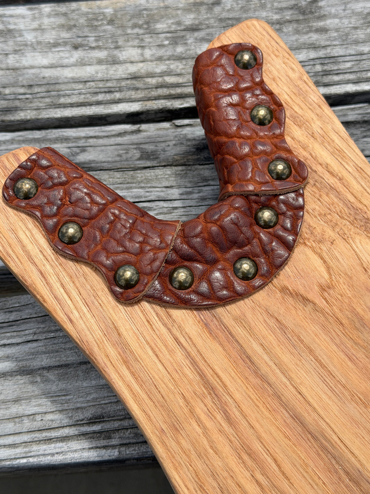 Close up view of bison leather accent from Wyoming with solid brass hardware on a boot jack for removing boots with ease