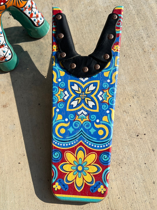Colorful floral-patterned tool with black handle on a concrete surface