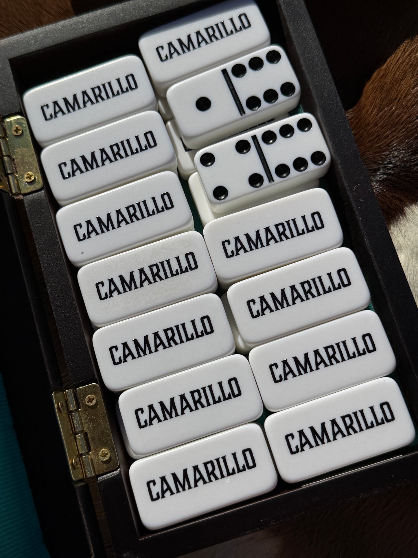Set of dominoes with 'Camarillo' branding in a wooden case.