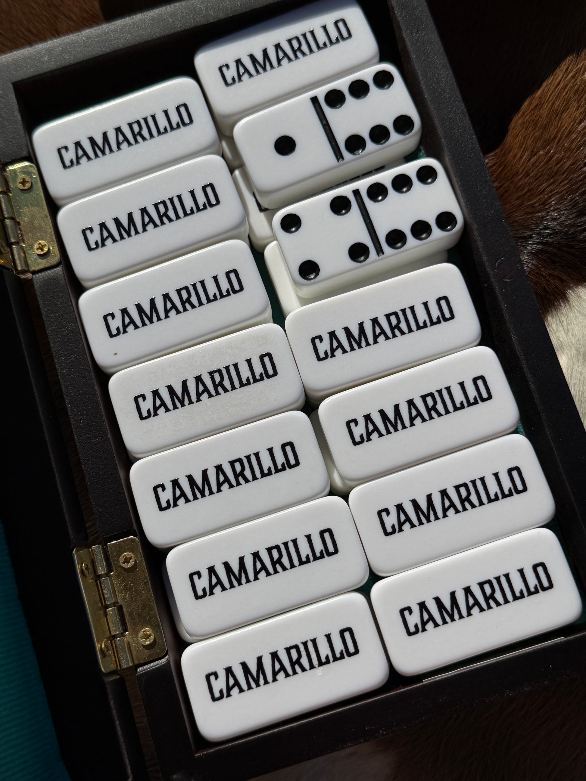 Set of dominoes with 'Camarillo' branding in a wooden case.