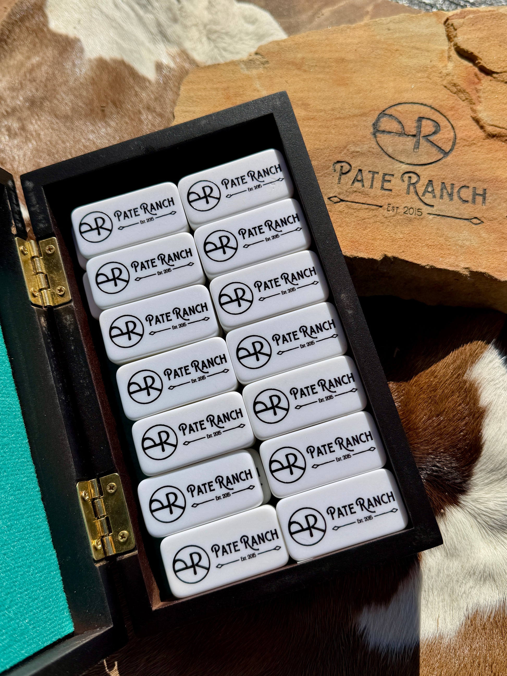 Set of Pate Ranch branded items in a wooden box on a rustic background
