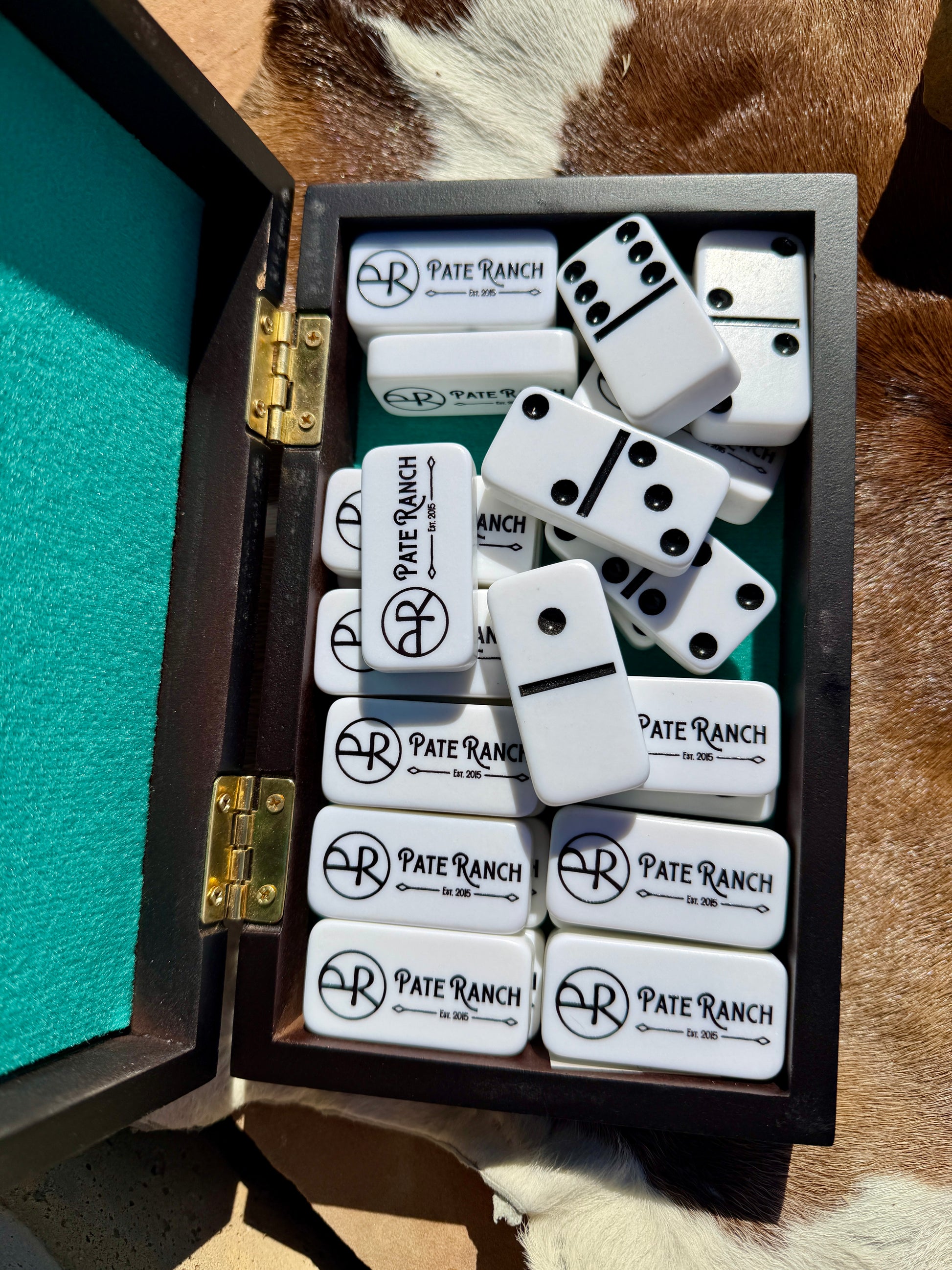 Pate Ranch dominoes set in a wooden box on a fur surface