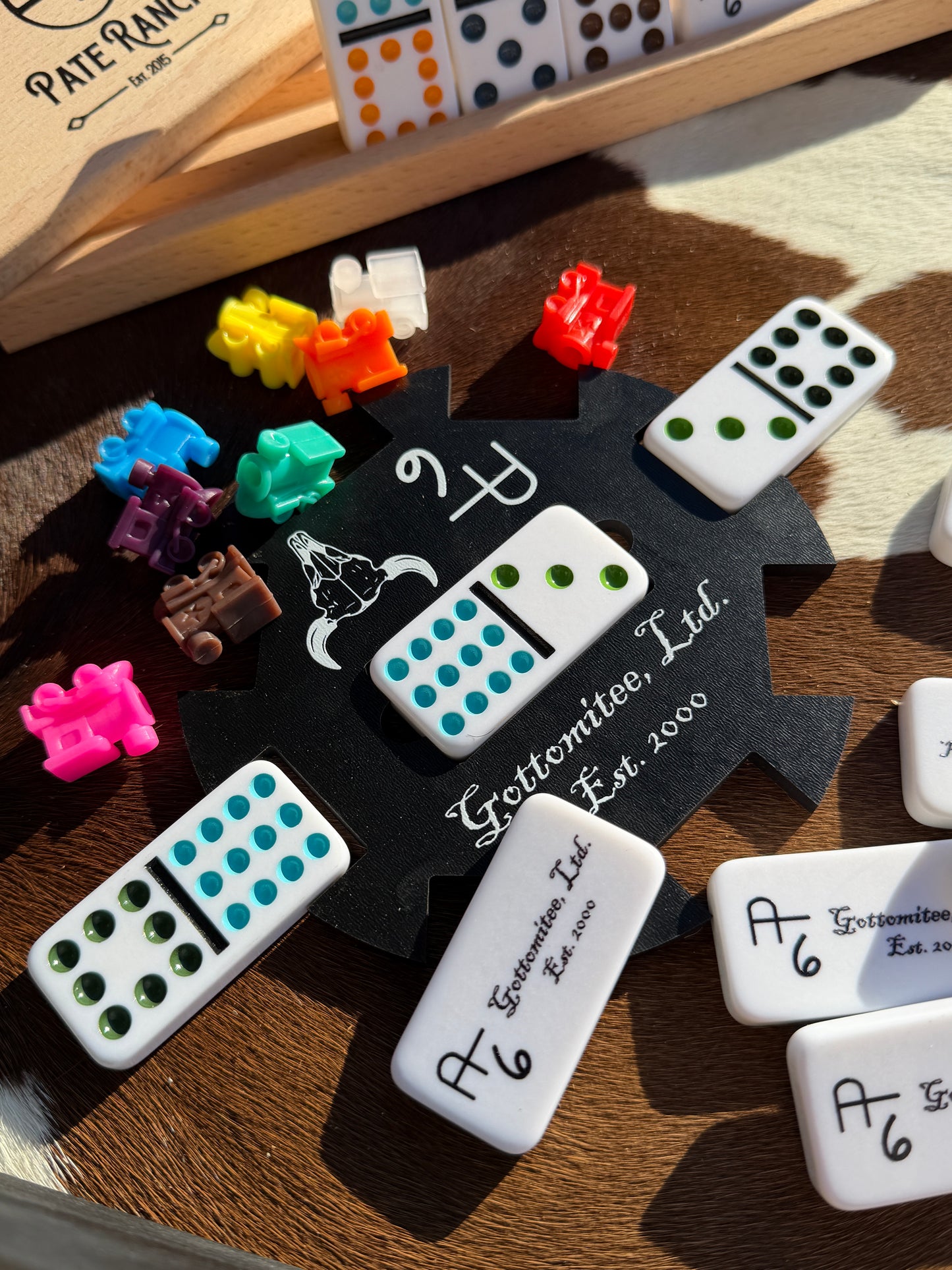 Collection of dominoes with various designs and numbers on a wooden surface