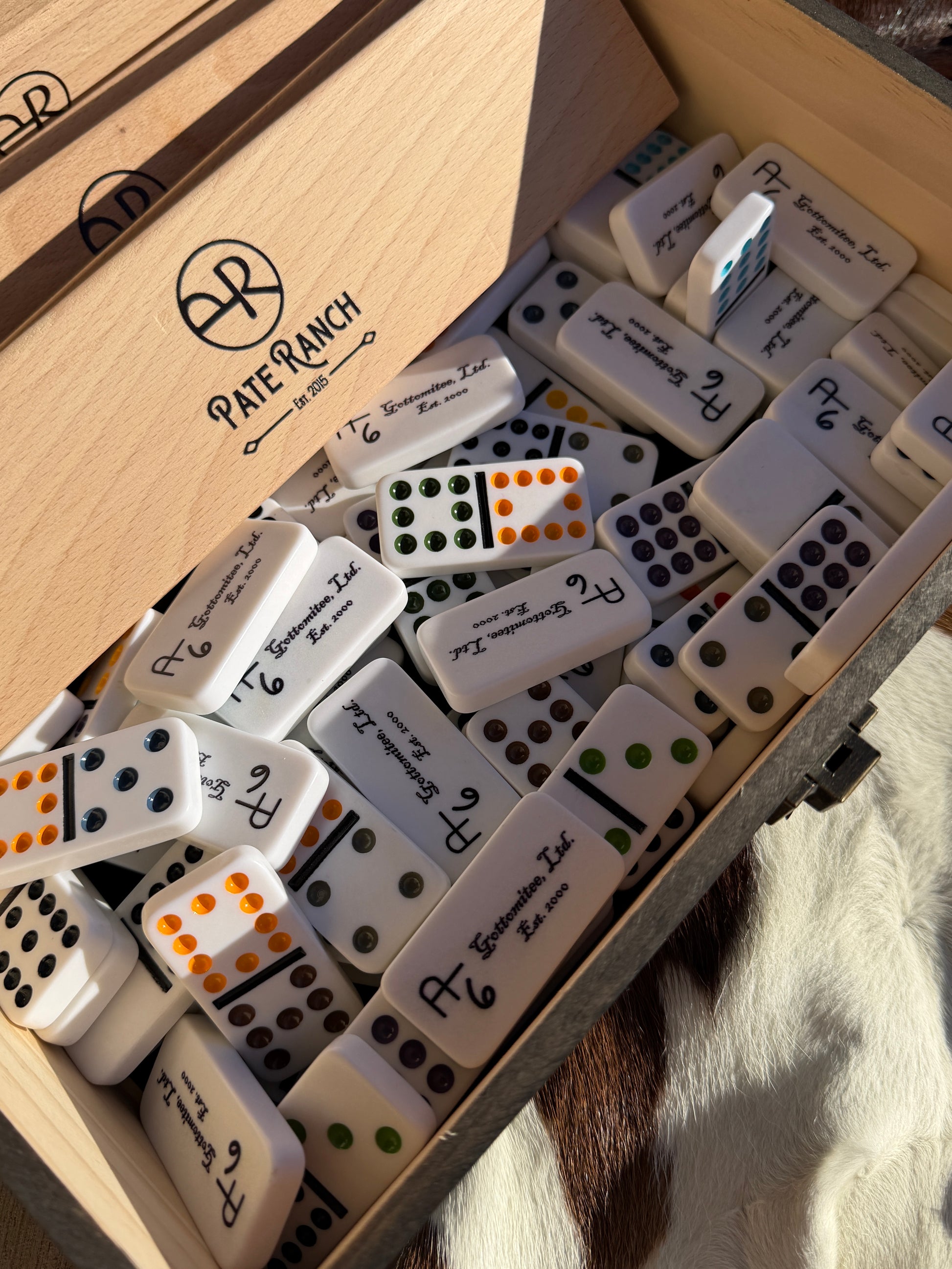 Dominoes set with a wooden box labeled 'Pare Parach' on a textured surface.