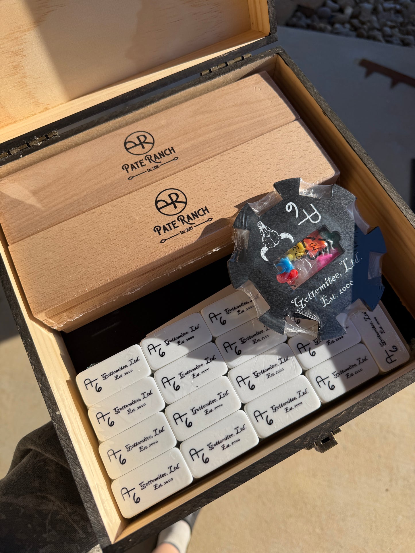 Set of branded labels in a wooden box with a visible brand logo.