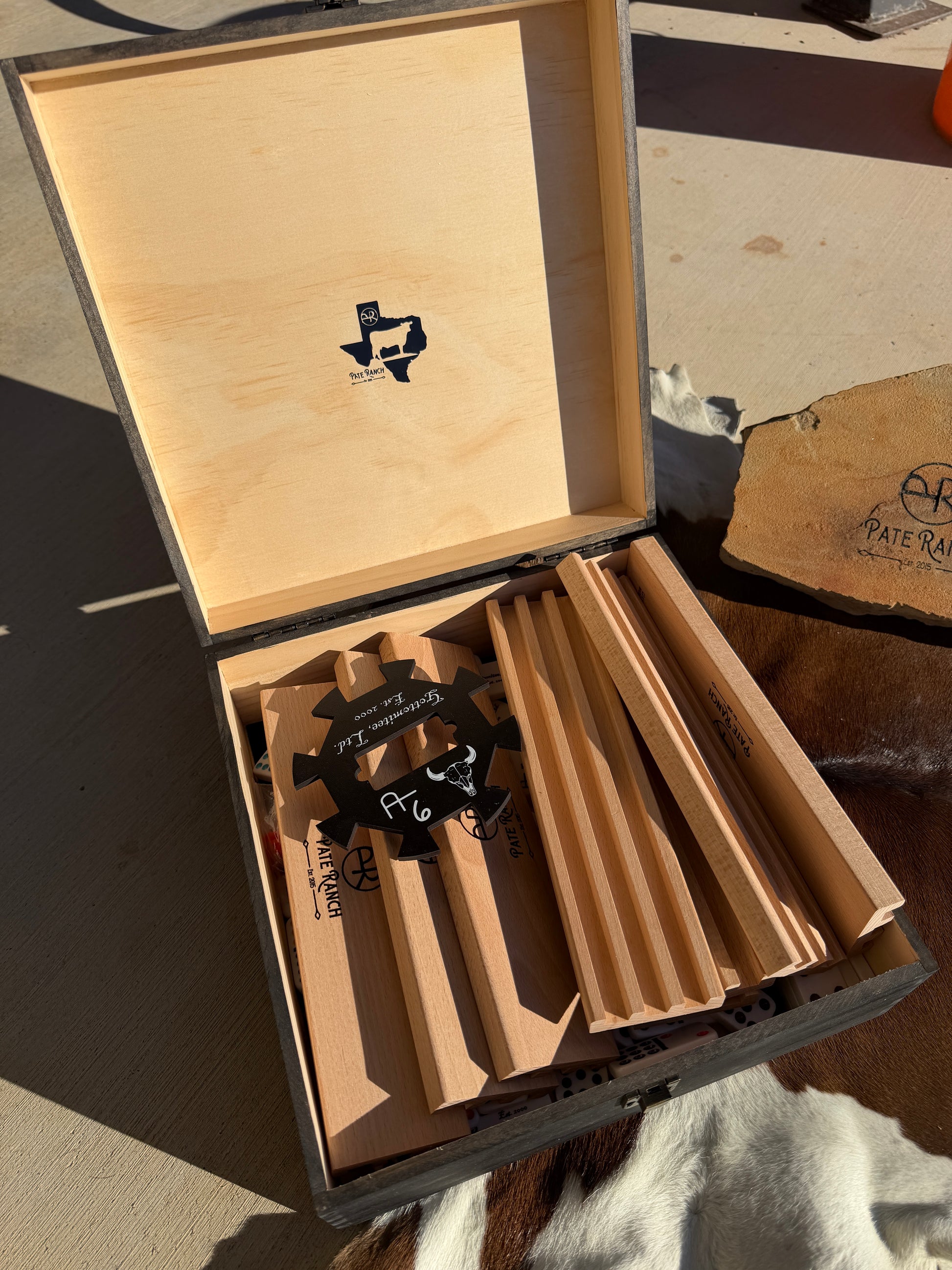 Open wooden box with branded items on a concrete surface