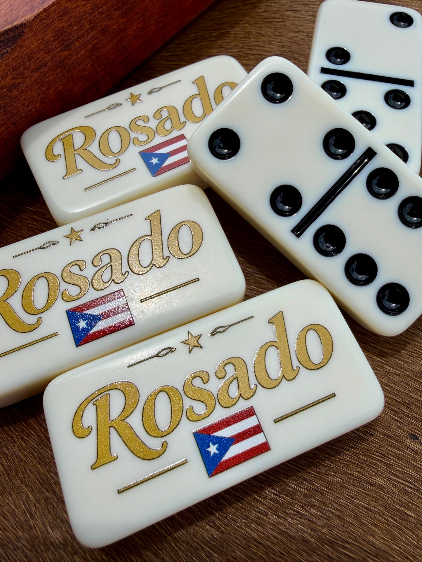 Dominoes with 'Rosado' branding and Puerto Rican flag on a wooden surface