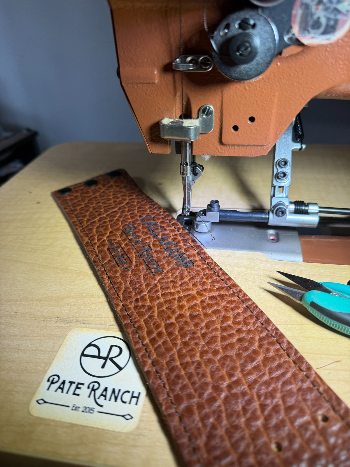 Pate Ranch workshop process stitching a genuine bison leather whiskey glass sleeve